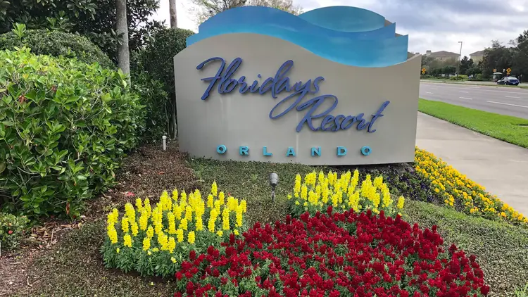 A sign reading Floridays Resort Orlando in a landscaped parkway