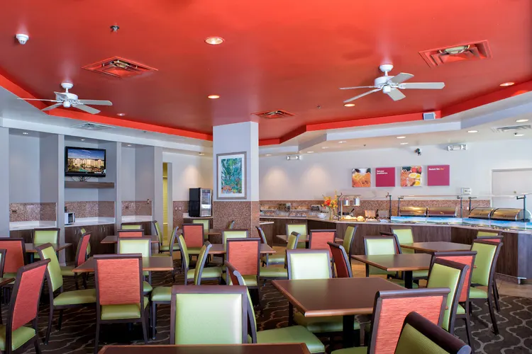 A dining area with buffet counters and tables with chairs