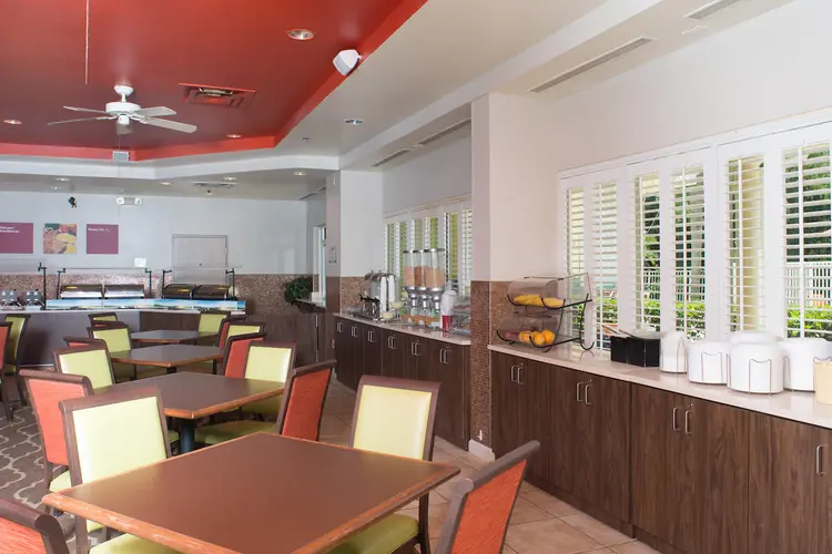 A dining area with a buffet counters and tables with chairs