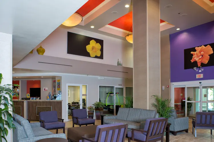 The Comfort Suites Maingate East lobby featuring artwork, counters and seating areas