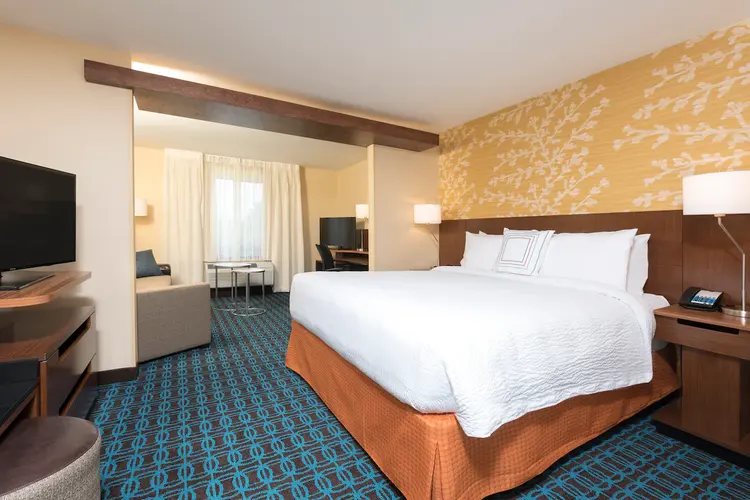 A king size bed in a room adjacent to a sitting area