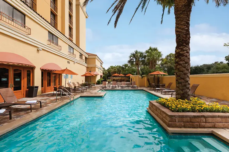 An outdoor pool with lounge chairs around the water