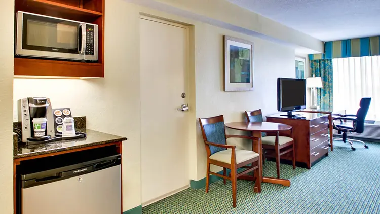 A hotel suite featuring a kitchenette area with a microwave, mini fridge and coffee maker