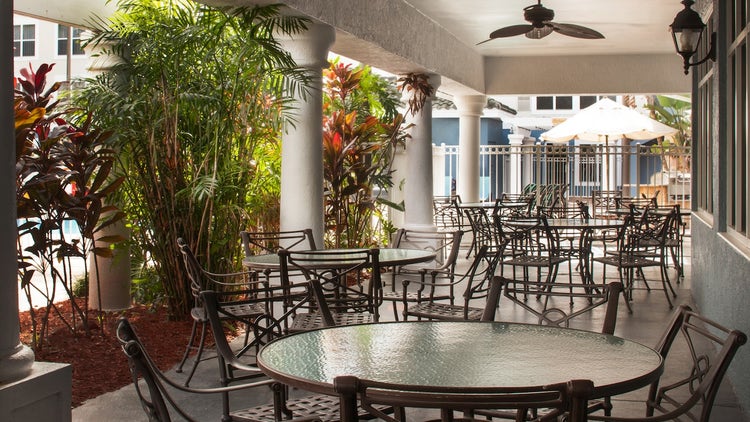 A covered patio with tables and chairs