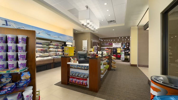 A convenience store with food, sundries and a center cashier island.