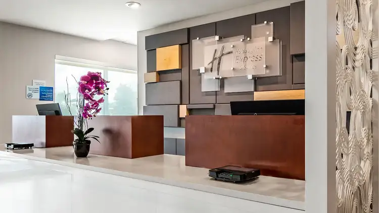 A front desk on a long counter and a large decorative letter ‘H’ on the wall