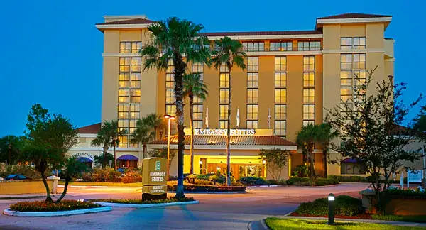 The hotel at dusk from the outside featuring palm trees