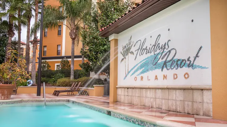 Water jets streaming into a swimming pool from a tile wall reading Floridays Resort Orlando